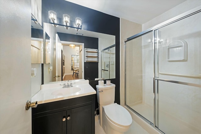 bathroom featuring an enclosed shower, vanity, and toilet