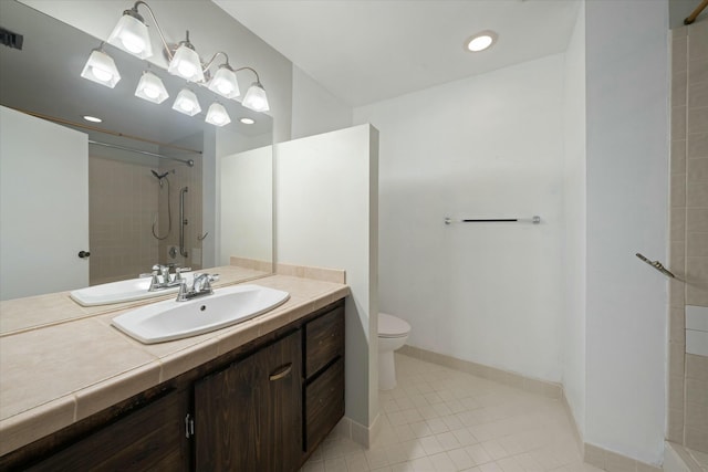 bathroom featuring toilet, vanity, tile patterned floors, and a tile shower