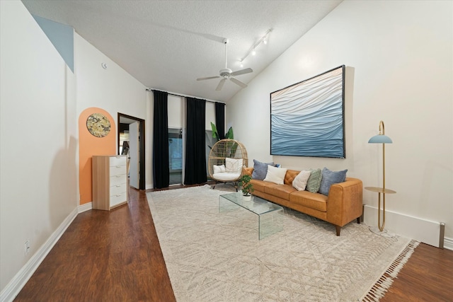 living room with a textured ceiling, hardwood / wood-style floors, track lighting, vaulted ceiling, and ceiling fan