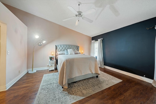 bedroom with a textured ceiling, ceiling fan, and dark hardwood / wood-style flooring