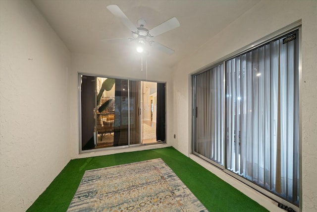 unfurnished sunroom with ceiling fan