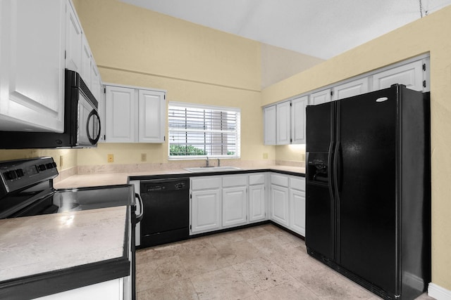 kitchen featuring lofted ceiling, sink, black appliances, and white cabinets