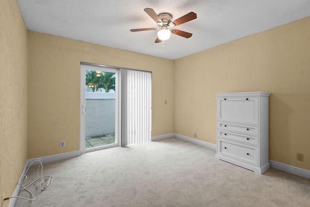 carpeted spare room with ceiling fan and a textured ceiling