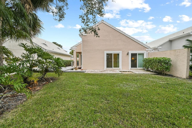 rear view of house featuring a patio and a yard