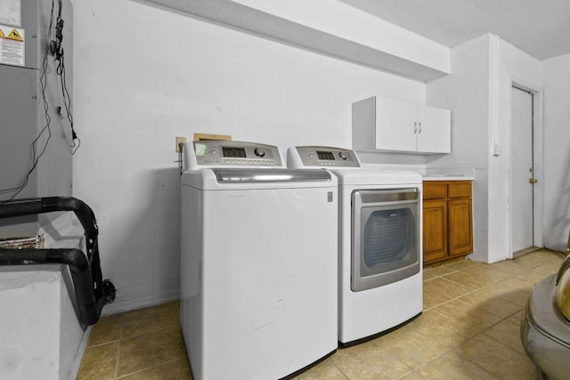 washroom with cabinets, washer and dryer, and light tile patterned floors