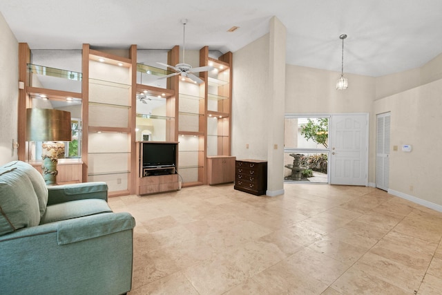 living room with ceiling fan and high vaulted ceiling