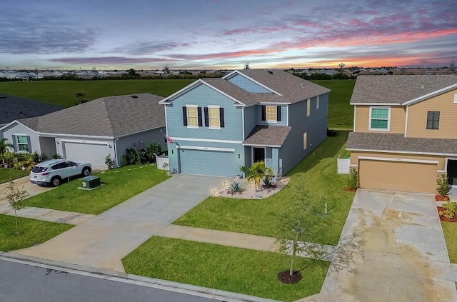 traditional-style house with concrete driveway, a shingled roof, a front yard, and a garage