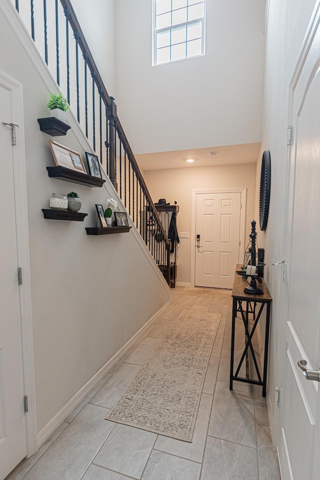 entrance foyer featuring light tile patterned flooring and a high ceiling