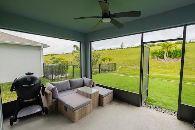 sunroom / solarium featuring ceiling fan and a rural view