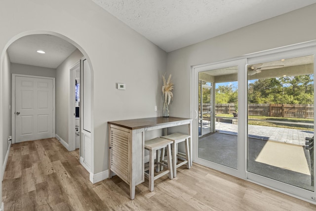 dining area with a textured ceiling and light wood-type flooring