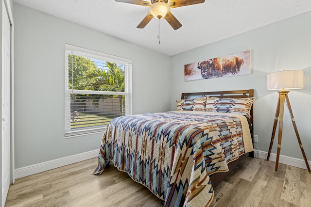 bedroom featuring wood-type flooring, ceiling fan, and a textured ceiling