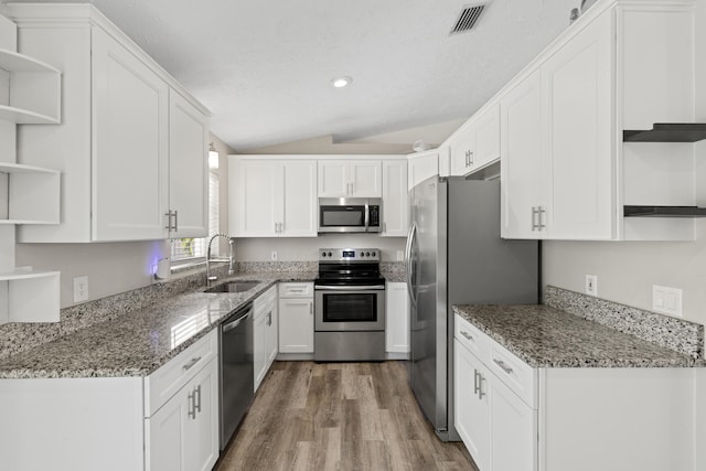 kitchen featuring white cabinetry, appliances with stainless steel finishes, sink, and dark stone counters