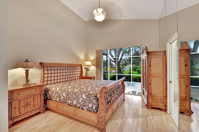 bedroom with ceiling fan, high vaulted ceiling, access to exterior, and hardwood / wood-style floors