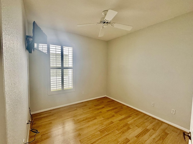 empty room with a ceiling fan, baseboards, and light wood finished floors