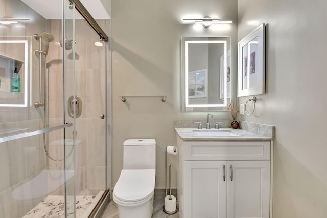 bathroom with vanity, a shower with door, and toilet