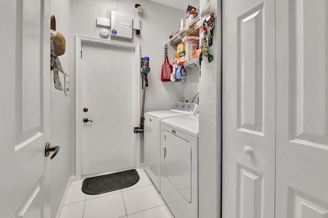 clothes washing area featuring light tile patterned floors and washing machine and dryer