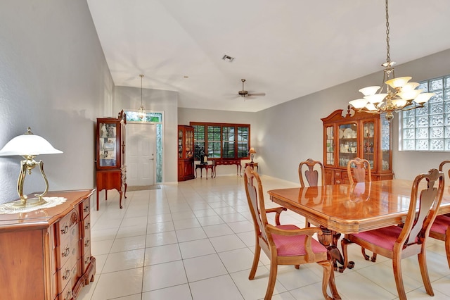 tiled dining room with ceiling fan with notable chandelier