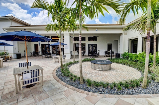 view of patio with ceiling fan and an outdoor fire pit