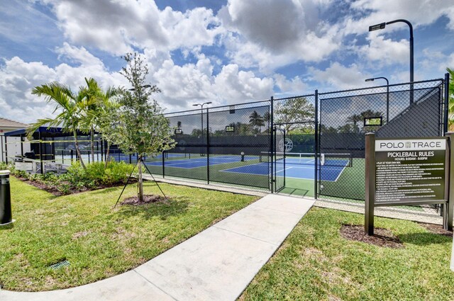 view of sport court with a gate, a lawn, and fence