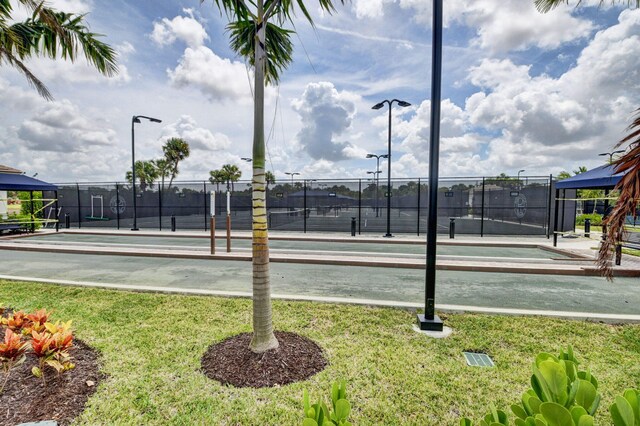 view of sport court with a yard and fence