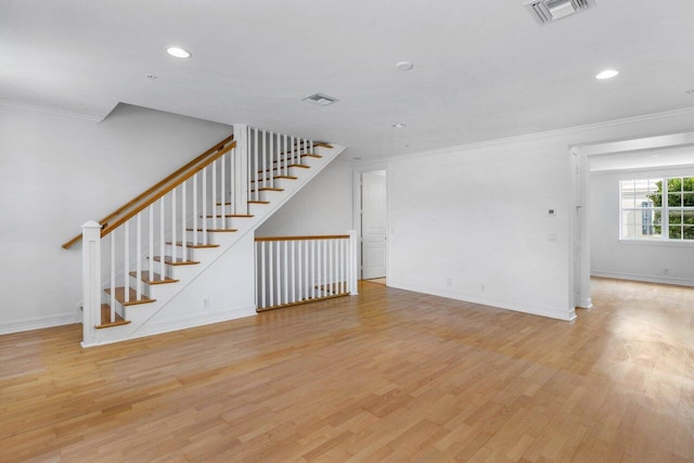 unfurnished living room with ornamental molding and light wood-type flooring