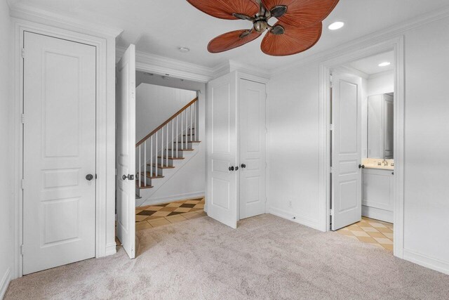 staircase with crown molding and tile patterned floors