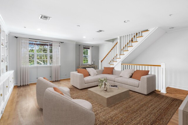 spare room featuring ornamental molding, built in features, and light hardwood / wood-style floors