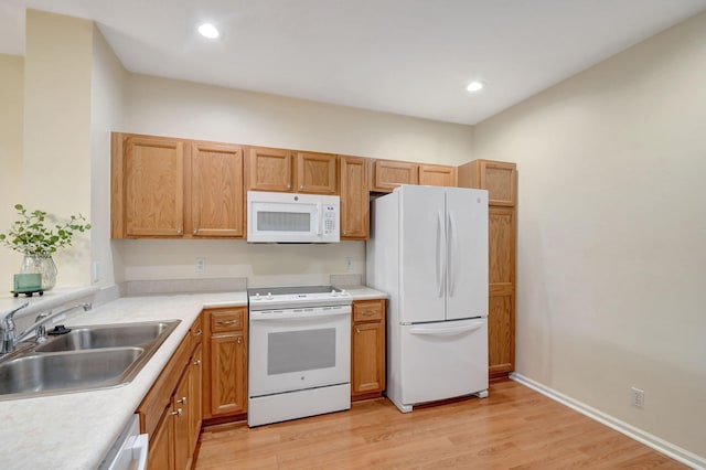 kitchen featuring sink, white appliances, and light hardwood / wood-style floors