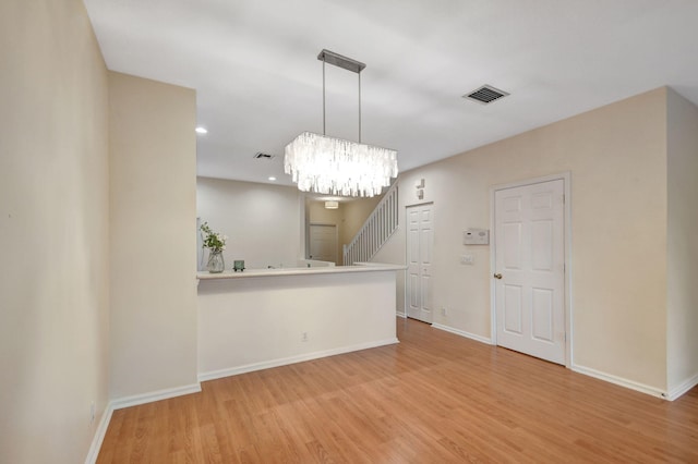 empty room featuring hardwood / wood-style flooring and a notable chandelier