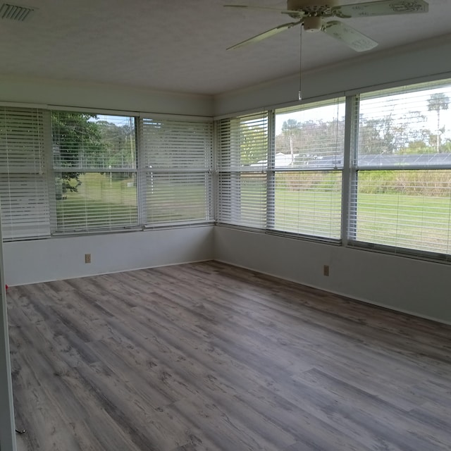 unfurnished sunroom featuring ceiling fan