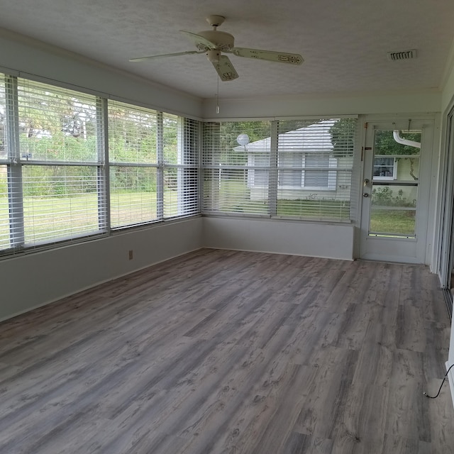 unfurnished sunroom featuring ceiling fan