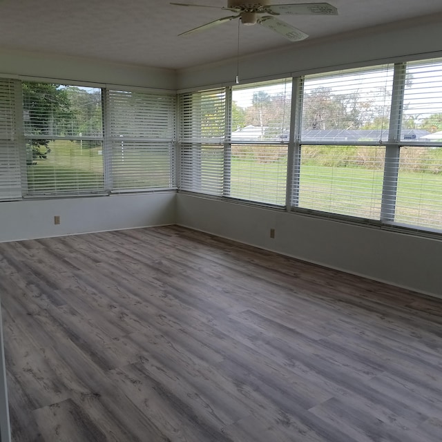 unfurnished sunroom featuring ceiling fan