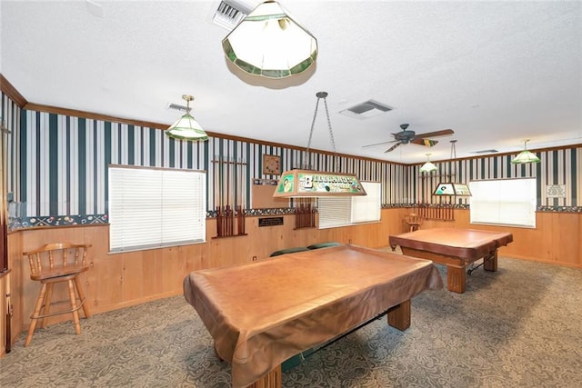 game room with pool table, ornamental molding, wooden walls, carpet floors, and ceiling fan