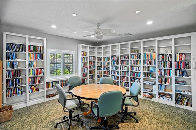 home office featuring ceiling fan, carpet, and a textured ceiling