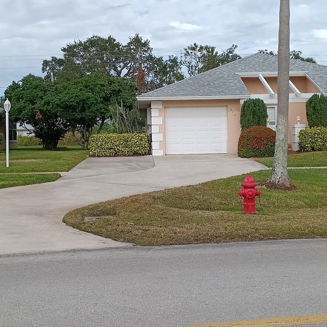 view of front of house featuring a garage and a front lawn