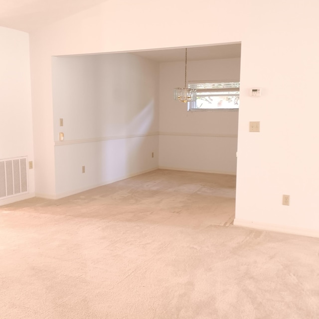 unfurnished room with carpet flooring and a notable chandelier