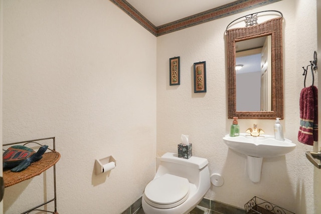 bathroom with crown molding and toilet