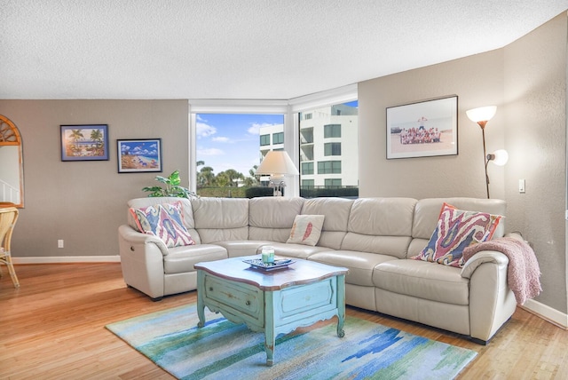 living room with a textured ceiling and light wood-type flooring