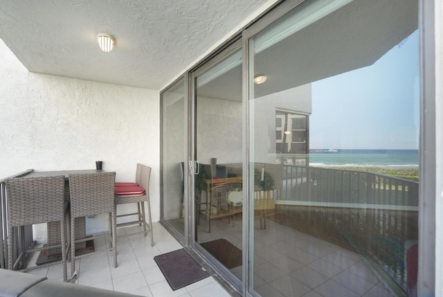 balcony with a water view and a beach view