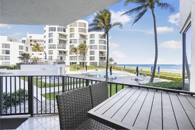 balcony featuring a beach view and a water view