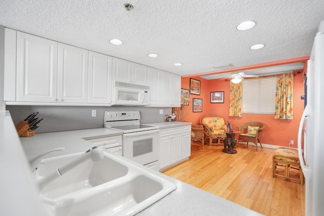 kitchen featuring white appliances, sink, and white cabinets