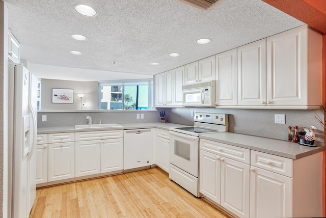 kitchen featuring sink, white appliances, light hardwood / wood-style flooring, and white cabinets