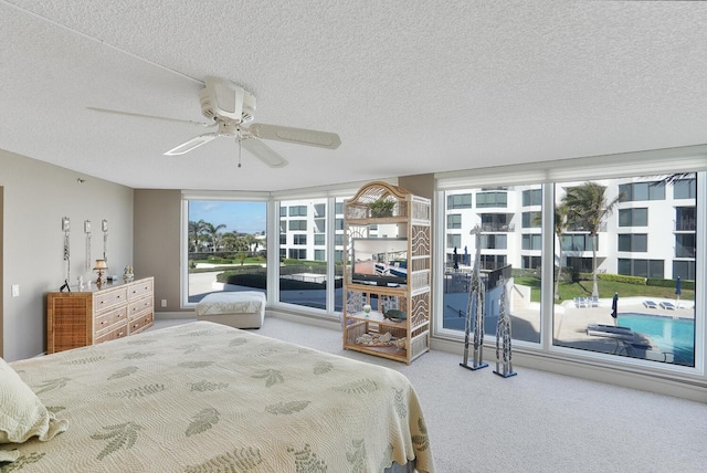 bedroom with ceiling fan, carpet, and a textured ceiling