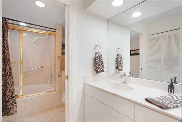 full bathroom with tile patterned flooring, bath / shower combo with glass door, vanity, and toilet