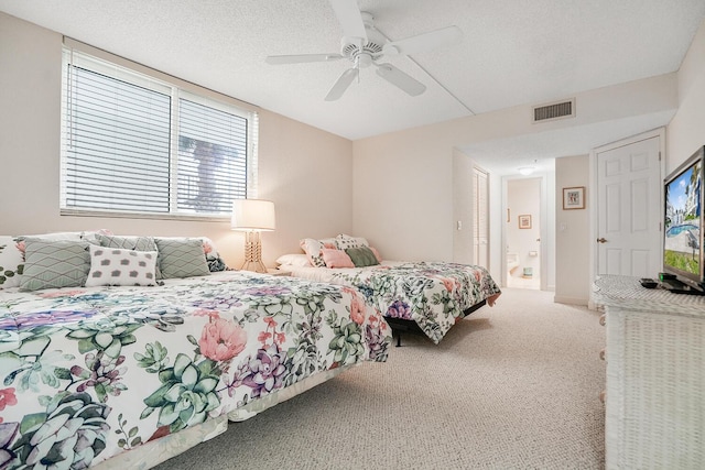 carpeted bedroom featuring ceiling fan, connected bathroom, and a textured ceiling