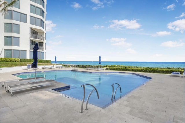 view of pool featuring a water view and a patio