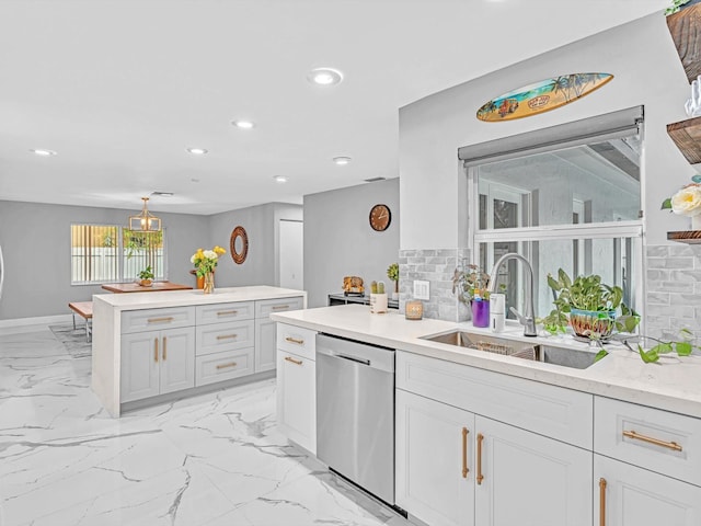 kitchen featuring white cabinets, dishwasher, decorative backsplash, sink, and hanging light fixtures