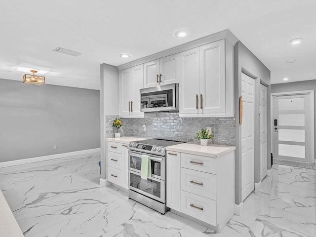 kitchen with stainless steel appliances, white cabinets, and tasteful backsplash