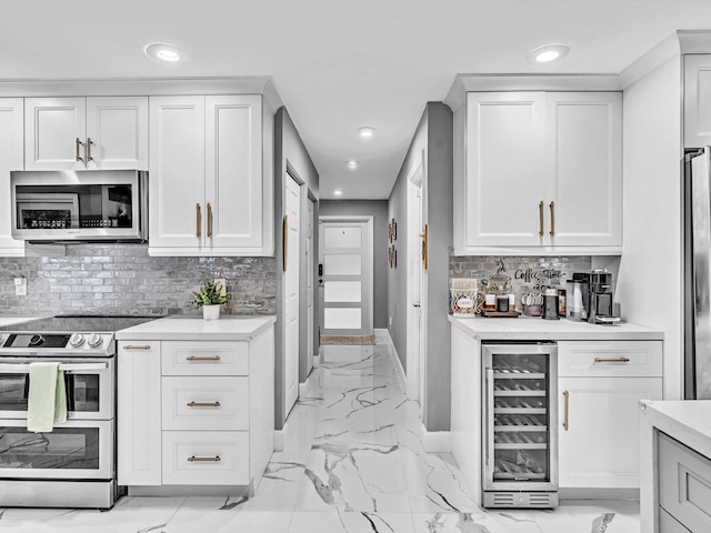 kitchen featuring white cabinetry, beverage cooler, stainless steel appliances, and tasteful backsplash