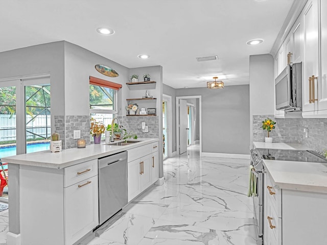 kitchen with white cabinets, backsplash, sink, and stainless steel appliances